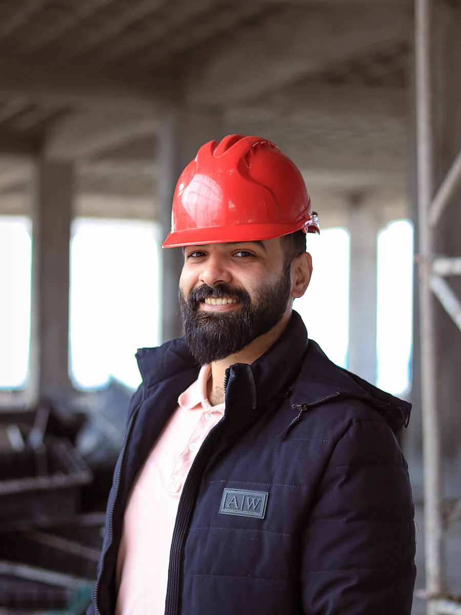 A smiling construction worker in a red hard hat